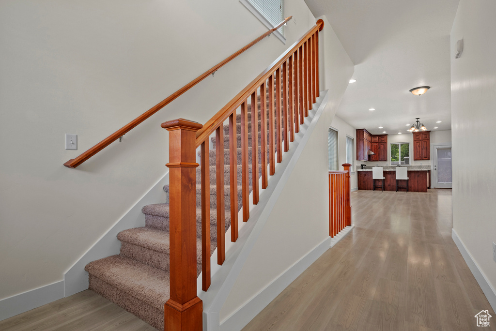 Stairway featuring wood finished floors, recessed lighting, and baseboards