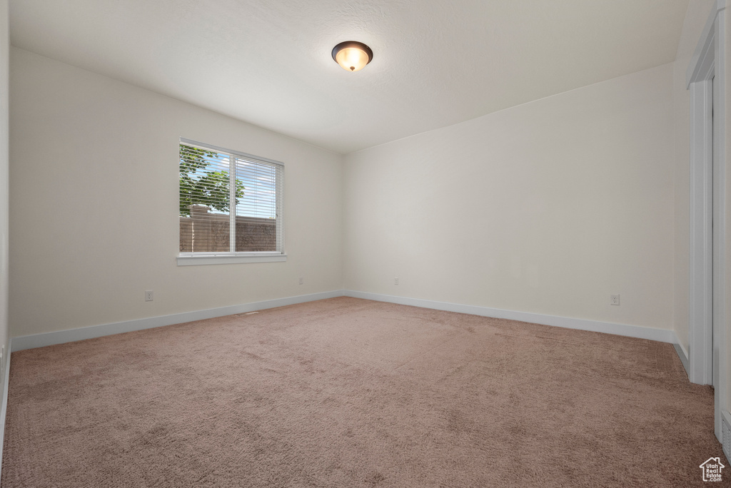 Spare room with light colored carpet and baseboards