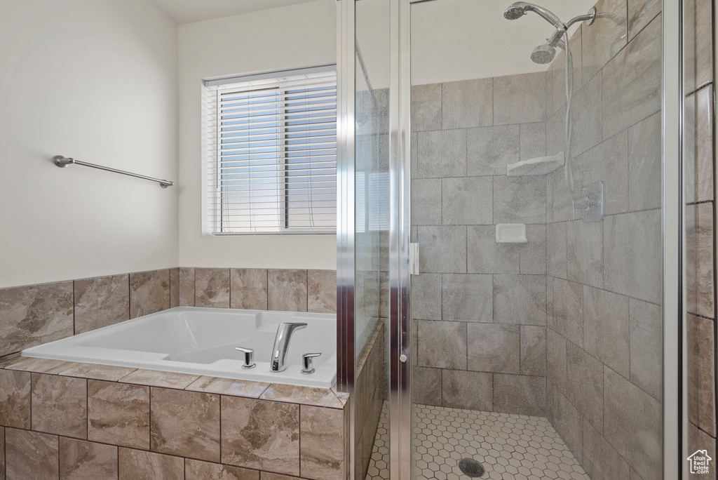 Full bath with a shower stall and a bath