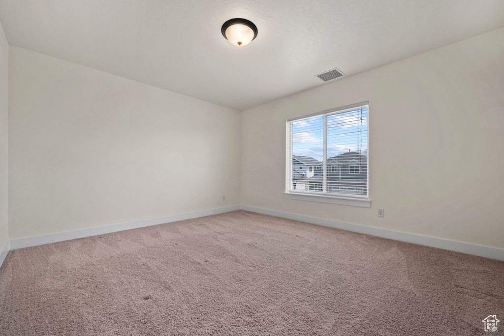 Unfurnished room featuring baseboards and light colored carpet