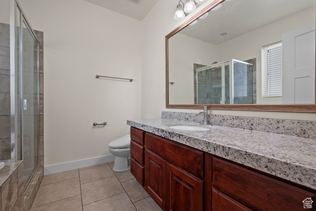 Bathroom with vanity, baseboards, tile patterned floors, toilet, and a shower stall