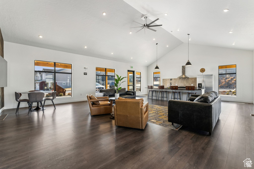 Living room with dark wood finished floors, high vaulted ceiling, a ceiling fan, recessed lighting, and baseboards