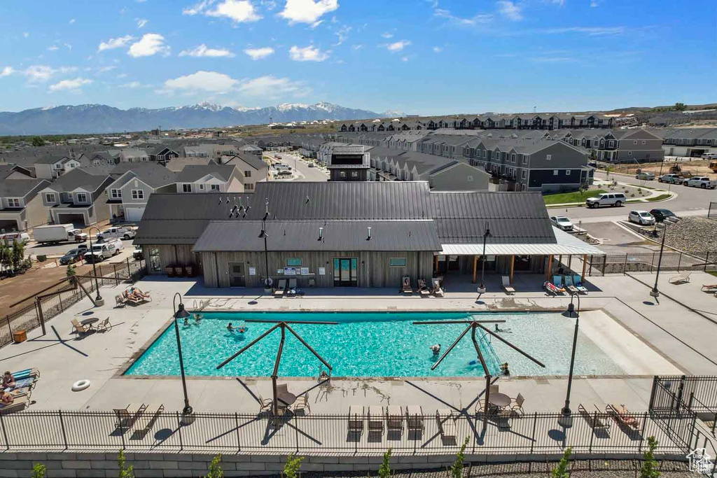 Community pool with a residential view, a patio, and a mountain view