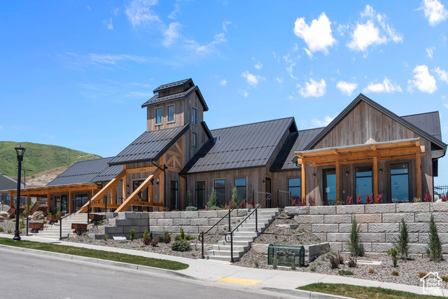 View of front of home with stairway, a standing seam roof, metal roof, and board and batten siding