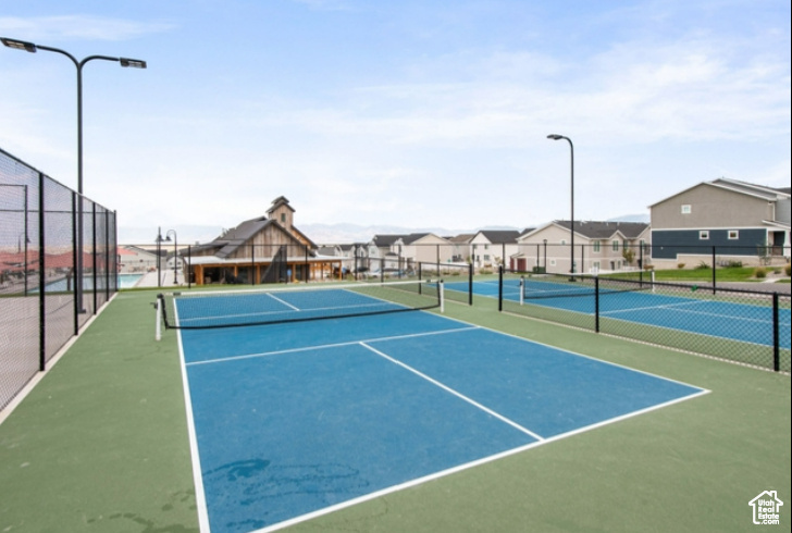 View of tennis court with a residential view