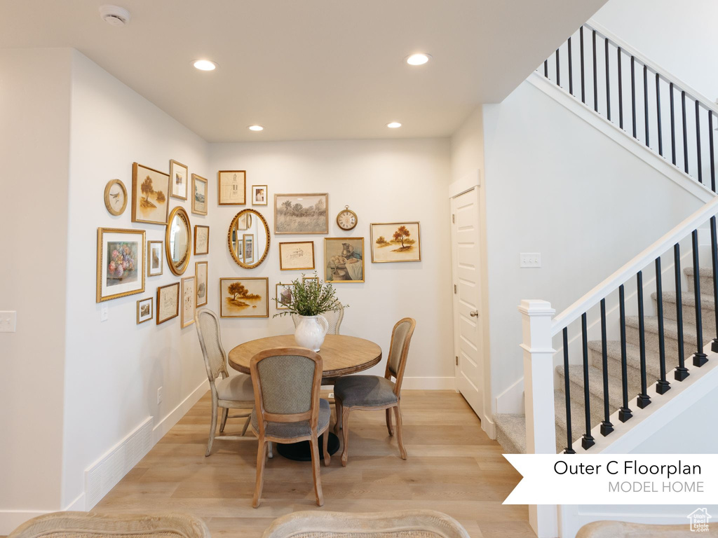 Dining room with light wood finished floors, recessed lighting, stairs, and baseboards
