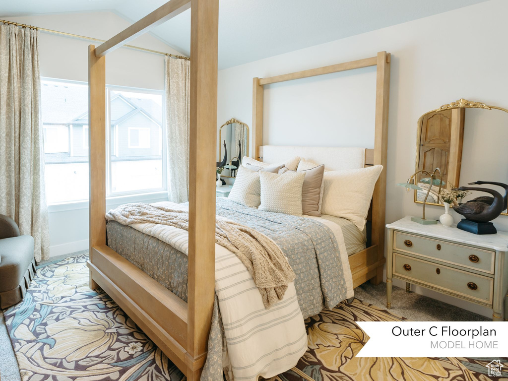 Bedroom with light colored carpet and vaulted ceiling
