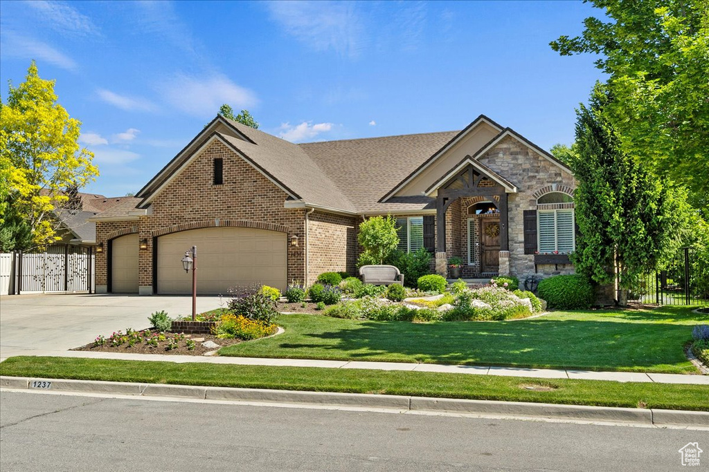 View of front of home with brick siding, an attached garage, and concrete driveway