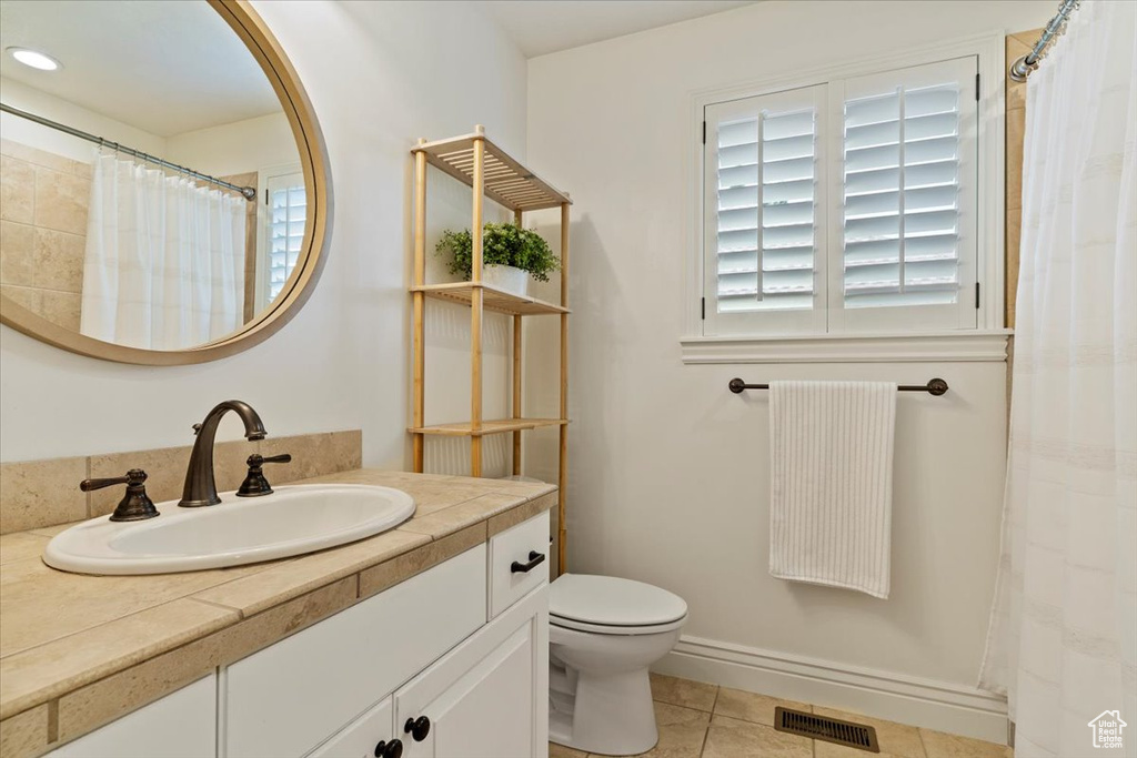 Bathroom featuring vanity, toilet, tile patterned floors, and a shower with curtain