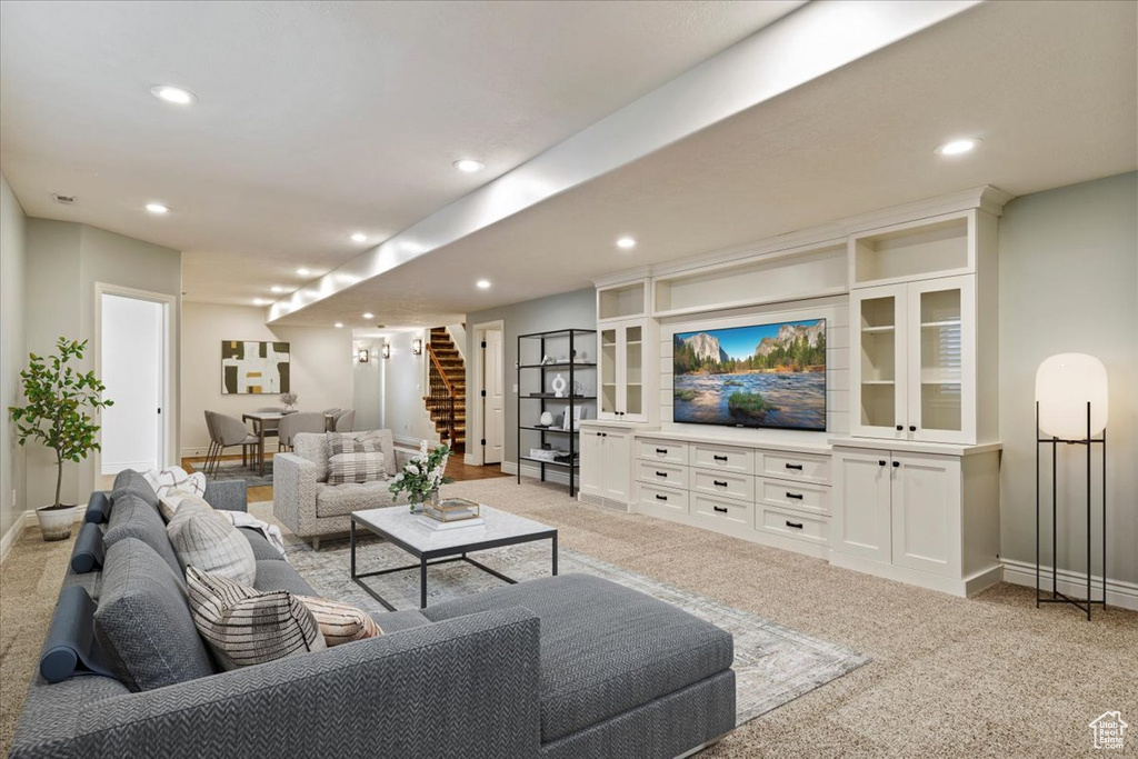 Living area with stairs, light carpet, recessed lighting, and baseboards