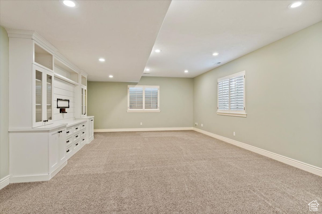 Unfurnished living room featuring light colored carpet, recessed lighting, and baseboards