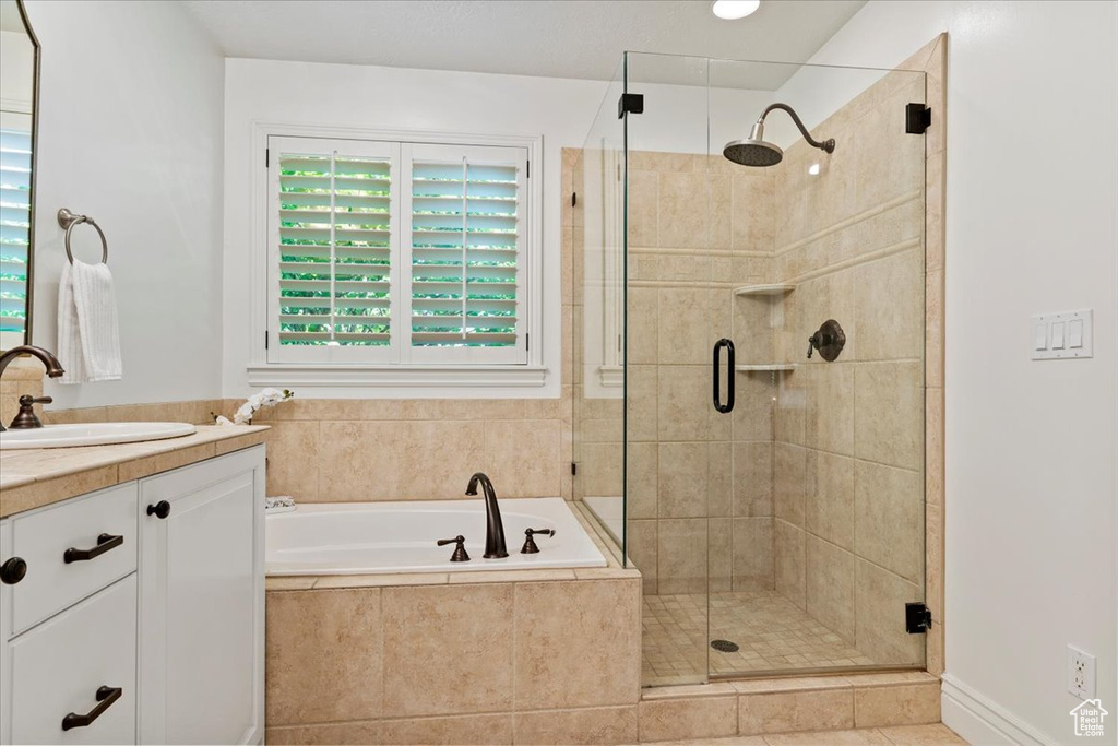 Full bathroom featuring a shower stall, vanity, a garden tub, and tile patterned flooring