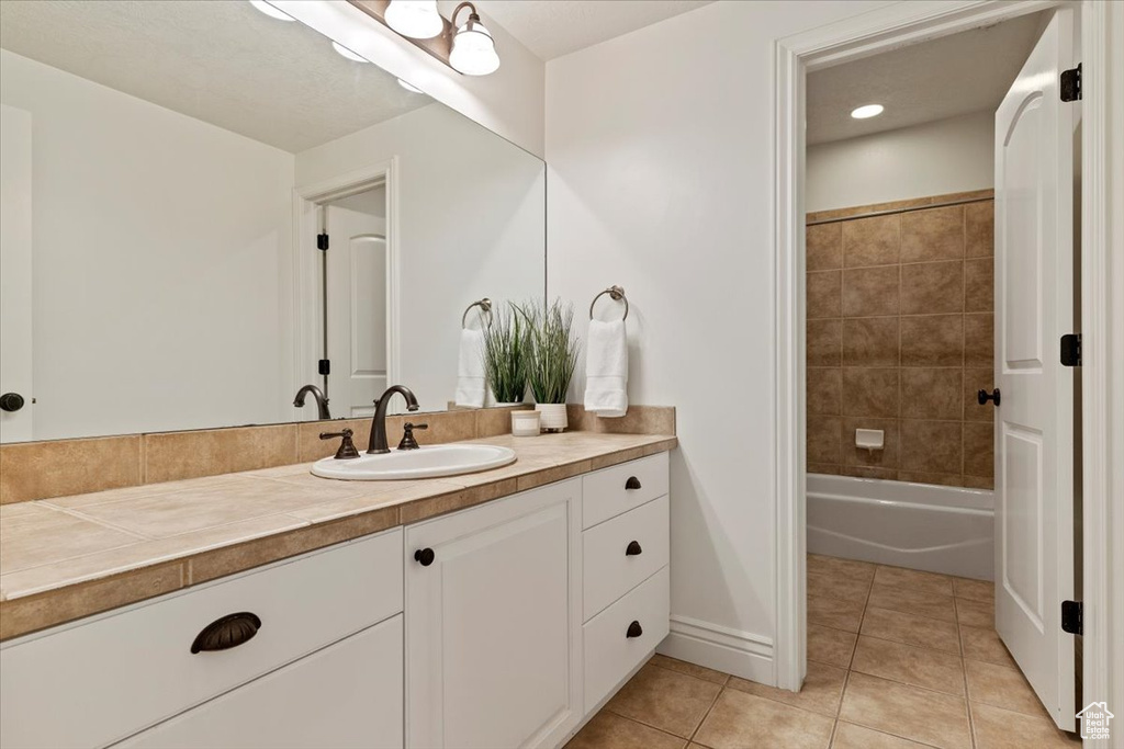 Full bath featuring vanity, tile patterned floors, baseboards, bathtub / shower combination, and recessed lighting