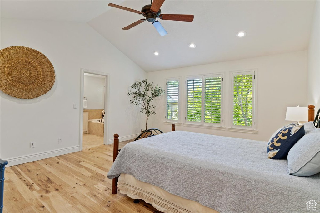 Bedroom with wood finished floors, recessed lighting, baseboards, vaulted ceiling, and connected bathroom