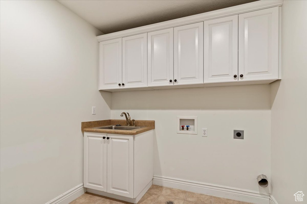 Washroom featuring hookup for an electric dryer, cabinet space, washer hookup, baseboards, and wet bar