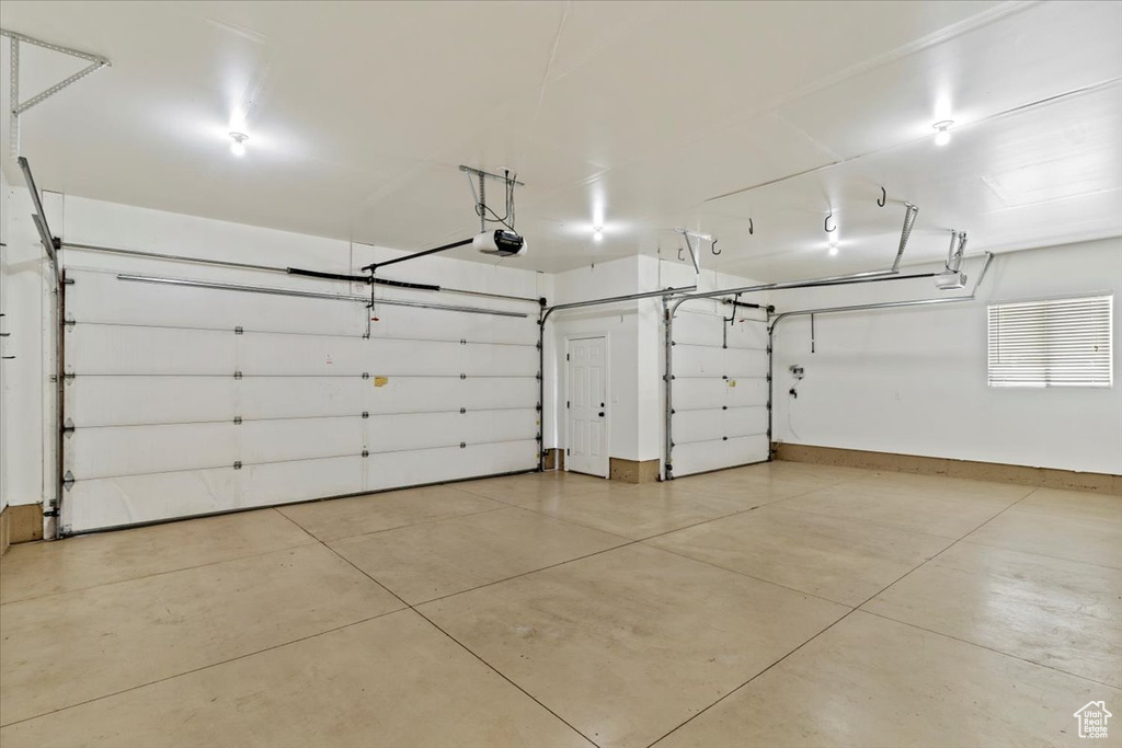Garage with a garage door opener and baseboards
