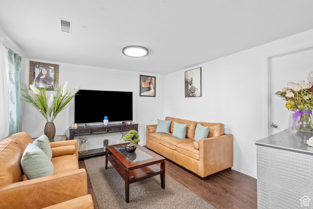 Living area with dark wood-type flooring and baseboards
