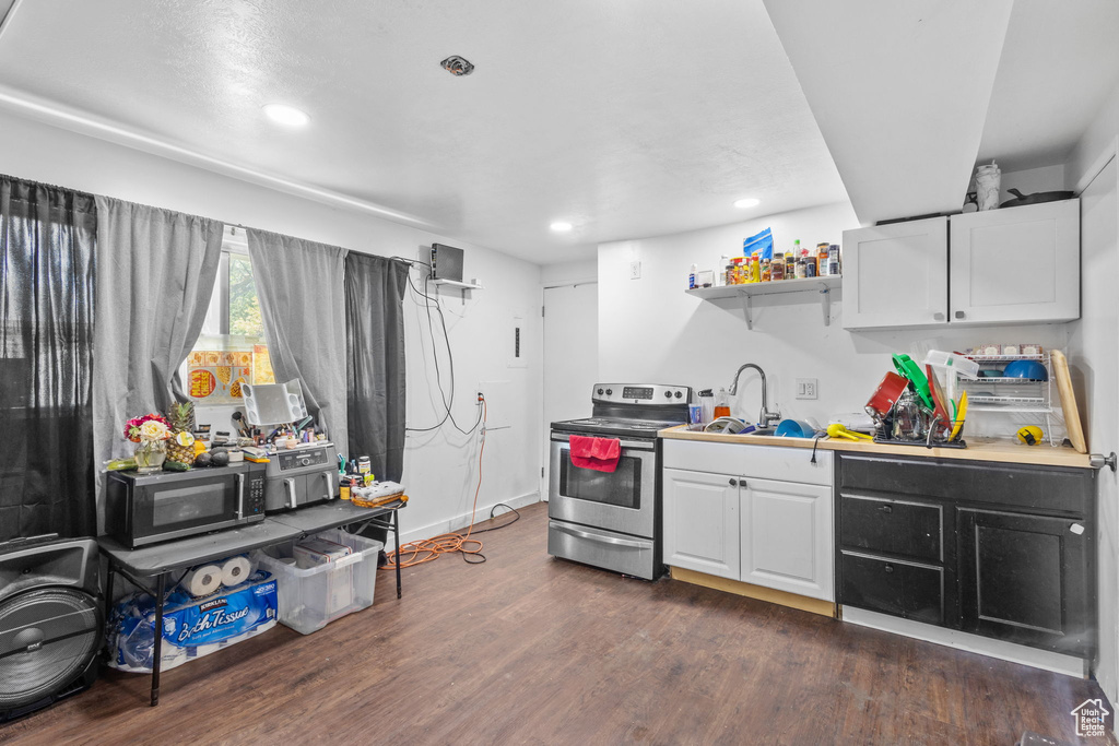 Kitchen with appliances with stainless steel finishes, a sink, dark wood-style flooring, recessed lighting, and white cabinetry