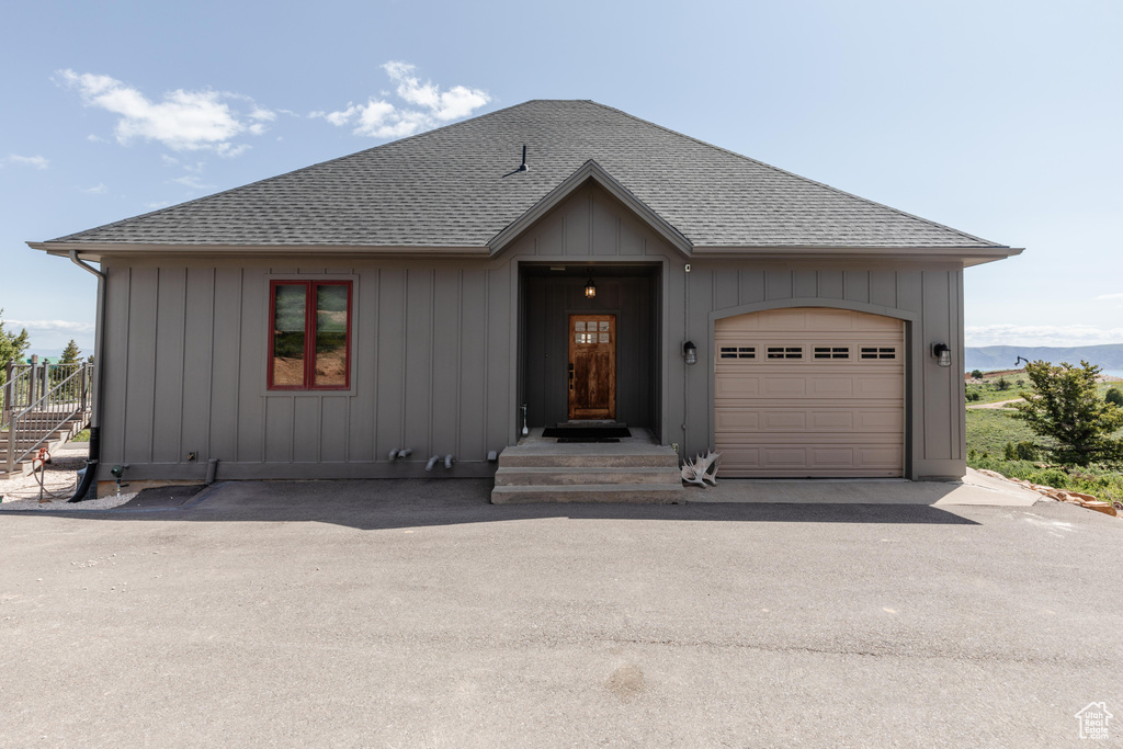 View of front of property featuring a shingled roof and board and batten siding