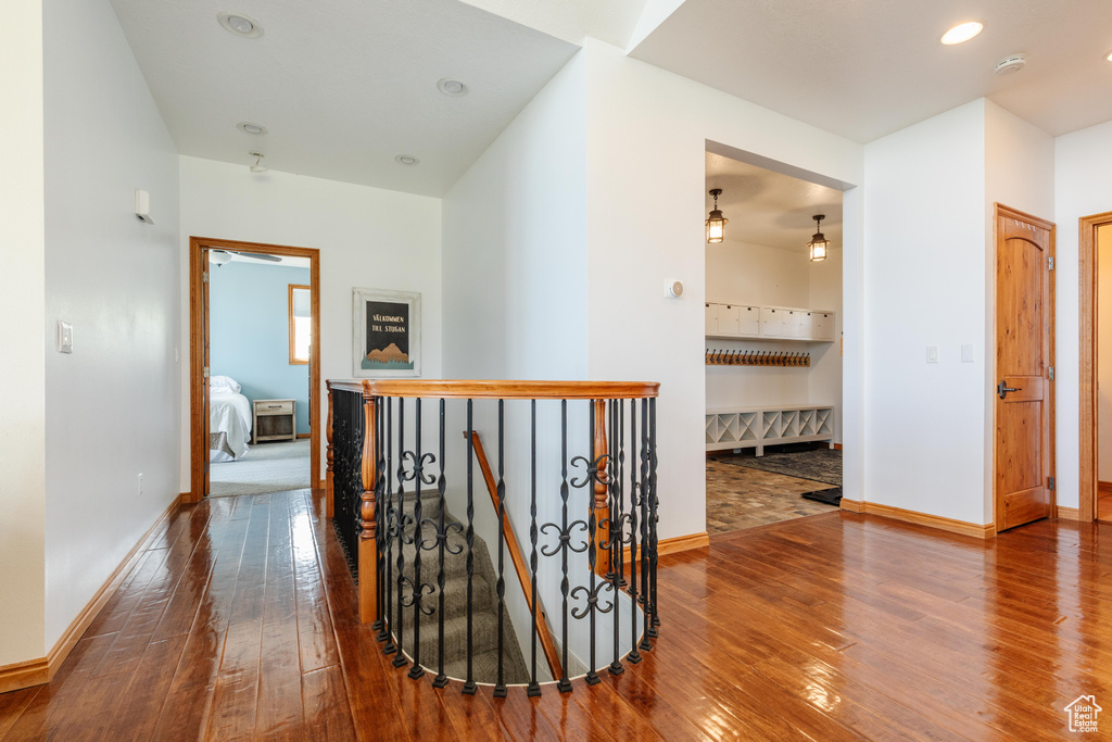 Hallway featuring an upstairs landing, hardwood / wood-style floors, and baseboards