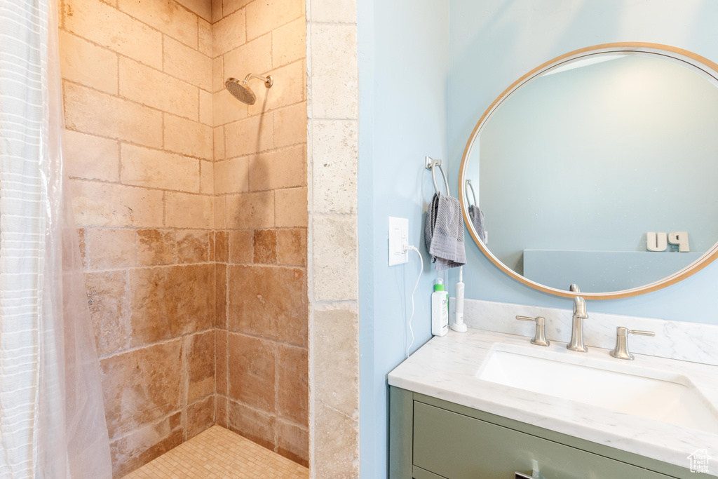 Bathroom featuring a tile shower and vanity