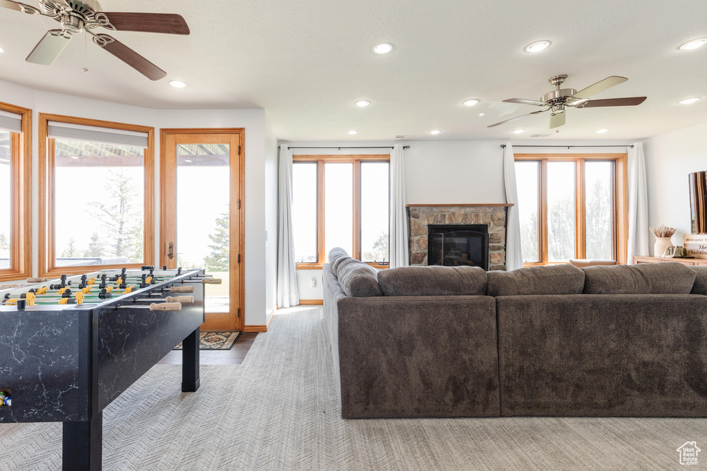 Living area with ceiling fan, recessed lighting, a fireplace, plenty of natural light, and baseboards