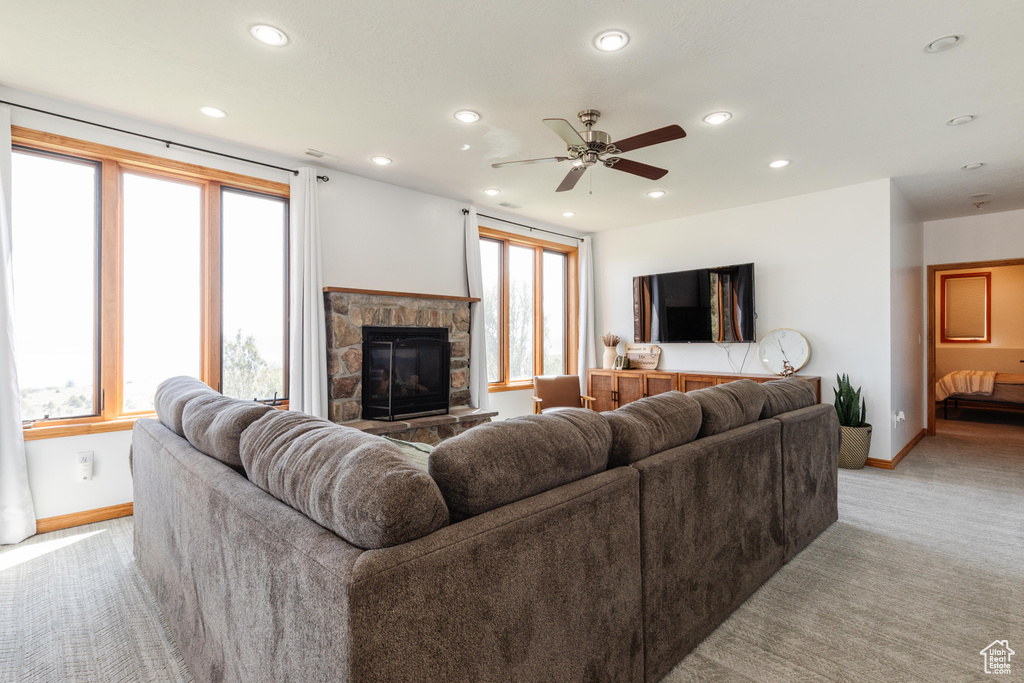 Living area with baseboards, light carpet, a fireplace, recessed lighting, and a ceiling fan