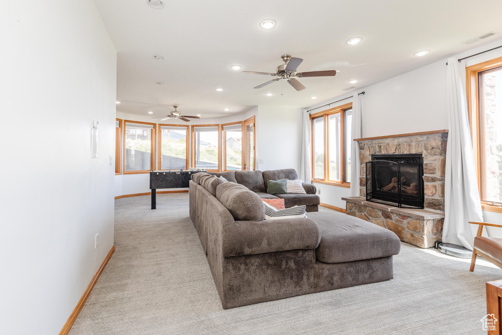 Living area with a ceiling fan, a stone fireplace, recessed lighting, baseboards, and plenty of natural light