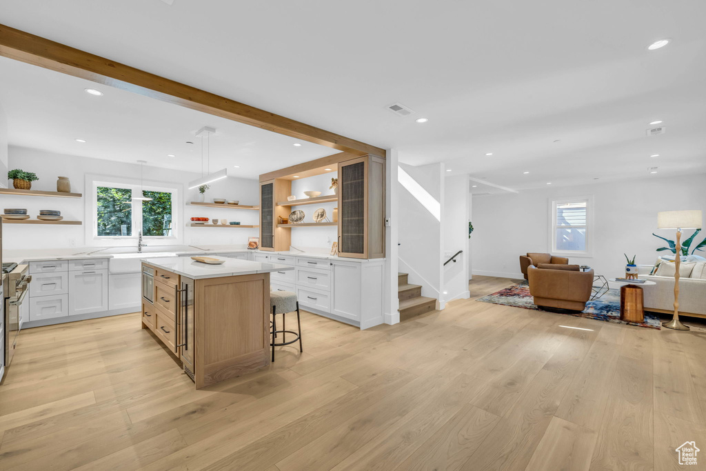Kitchen with open shelves, open floor plan, white cabinetry, light countertops, and recessed lighting