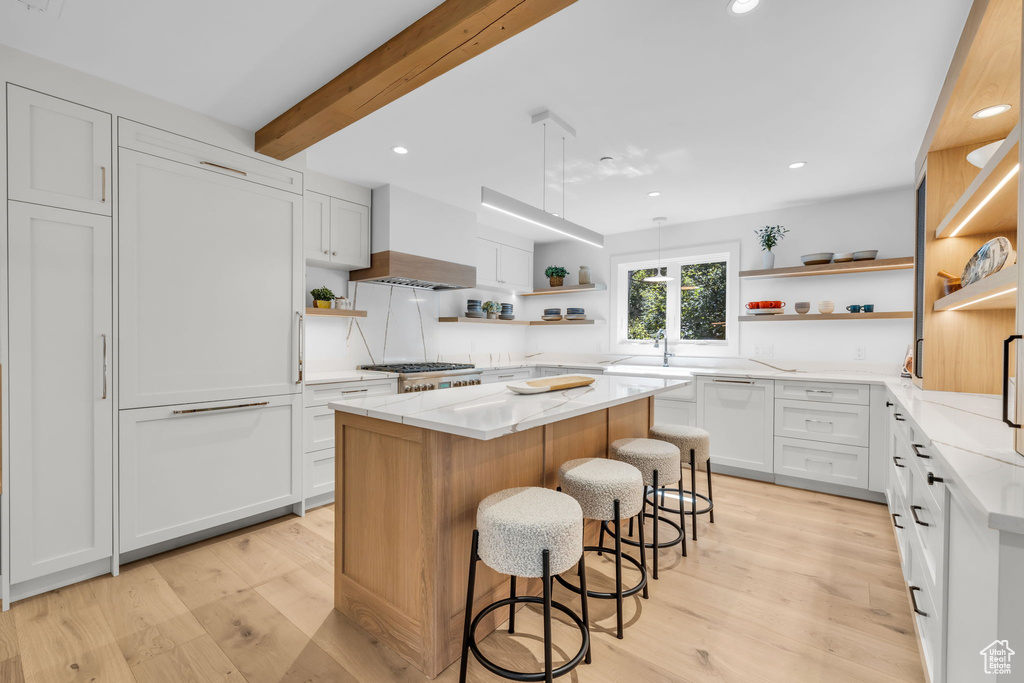 Kitchen with open shelves, premium range hood, a kitchen island, light wood-style floors, and recessed lighting