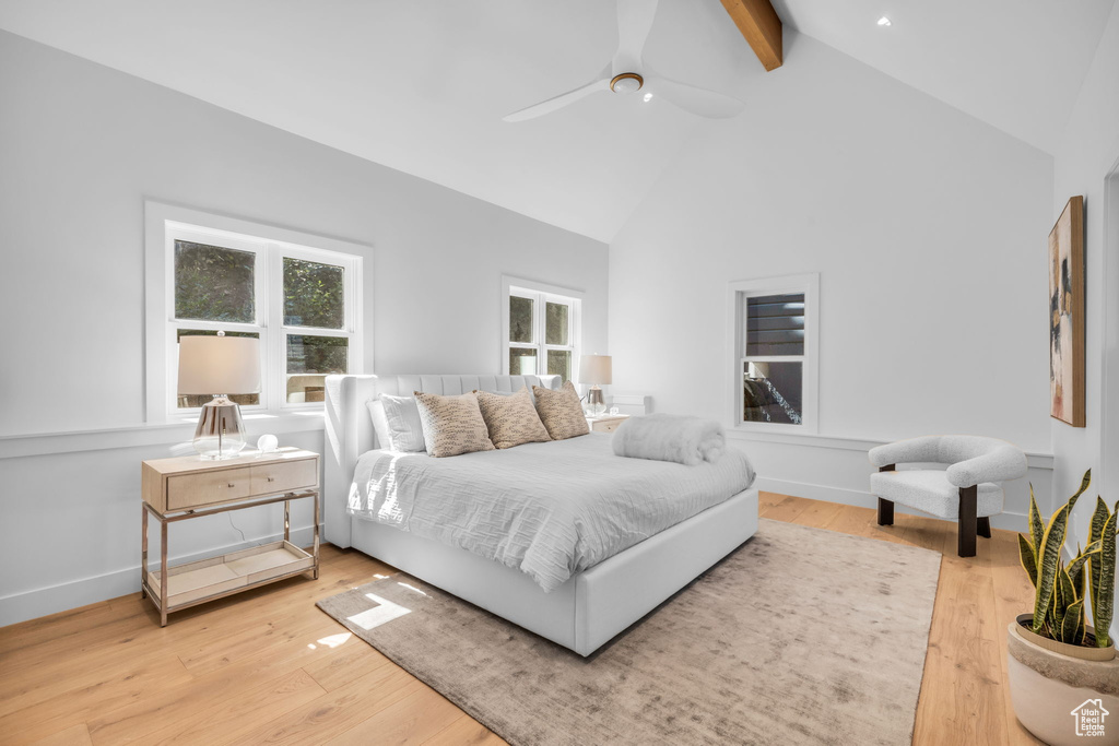 Bedroom with beamed ceiling, high vaulted ceiling, wood finished floors, ceiling fan, and baseboards