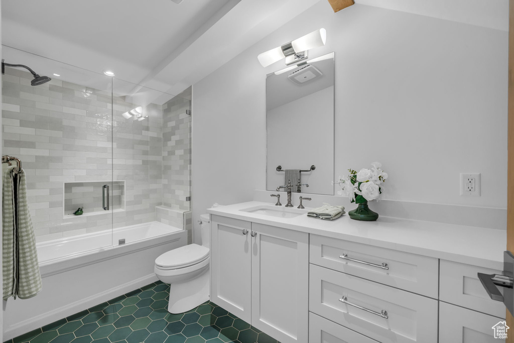 Bathroom featuring vanity, enclosed tub / shower combo, toilet, tile patterned flooring, and recessed lighting