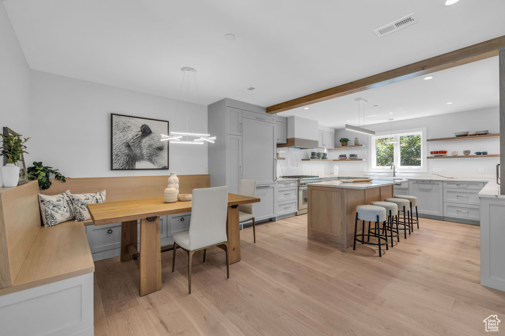 Dining space featuring light wood-style floors, breakfast area, beamed ceiling, and recessed lighting