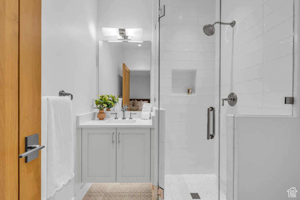 Ensuite bathroom featuring a shower stall and vanity