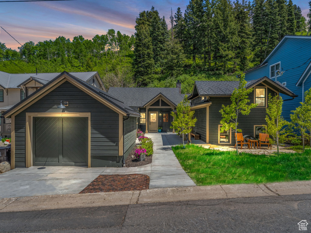 View of front facade featuring driveway and an attached garage
