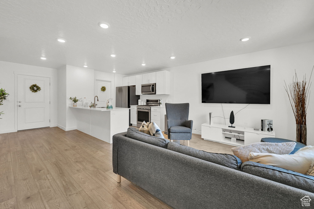 Living area featuring recessed lighting, light wood finished floors, and baseboards