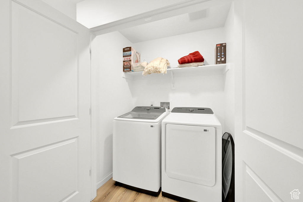 Washroom featuring separate washer and dryer and light wood-style flooring