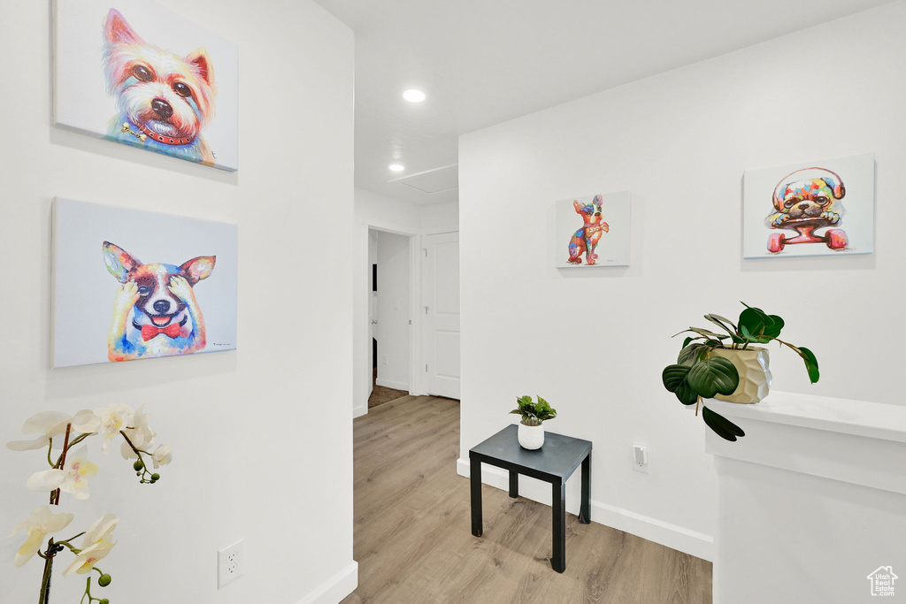 Corridor featuring baseboards, light wood-type flooring, and recessed lighting