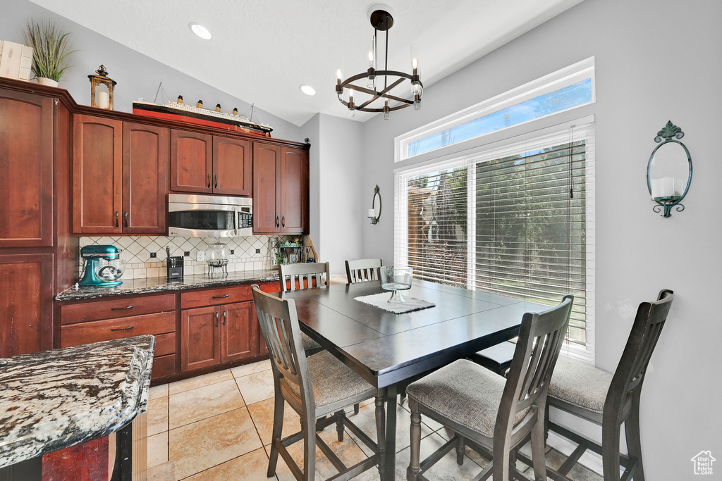Dining area with a chandelier, recessed lighting, and light tile patterned floors