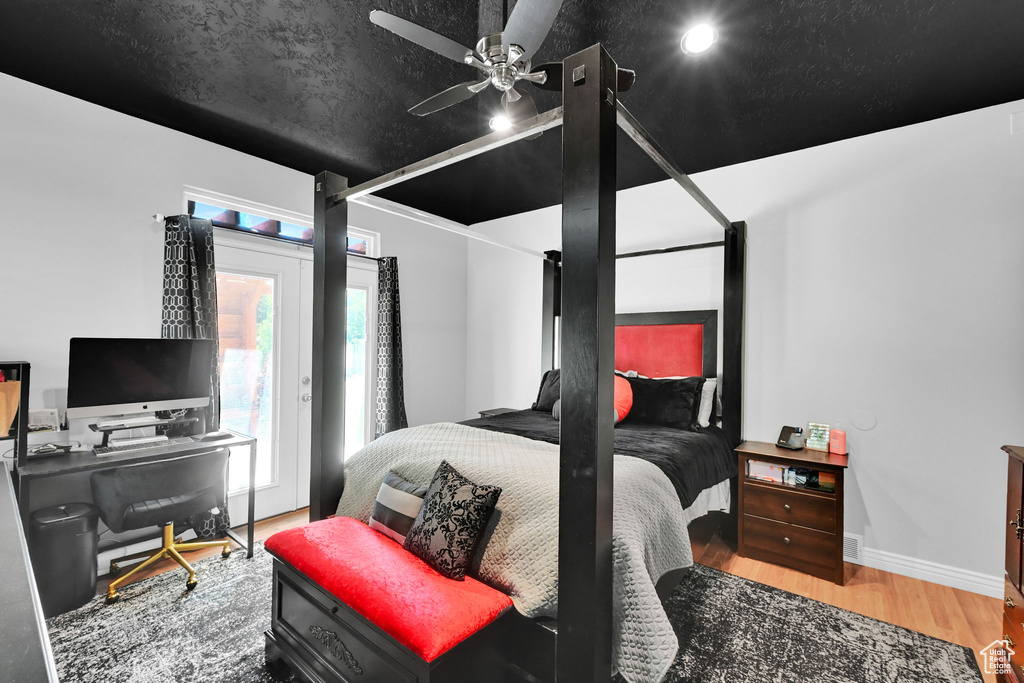 Bedroom featuring wood finished floors, a desk, access to outside, baseboards, and a ceiling fan