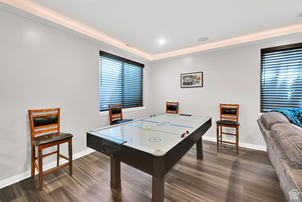 Game room featuring baseboards, dark wood-type flooring, and ornamental molding