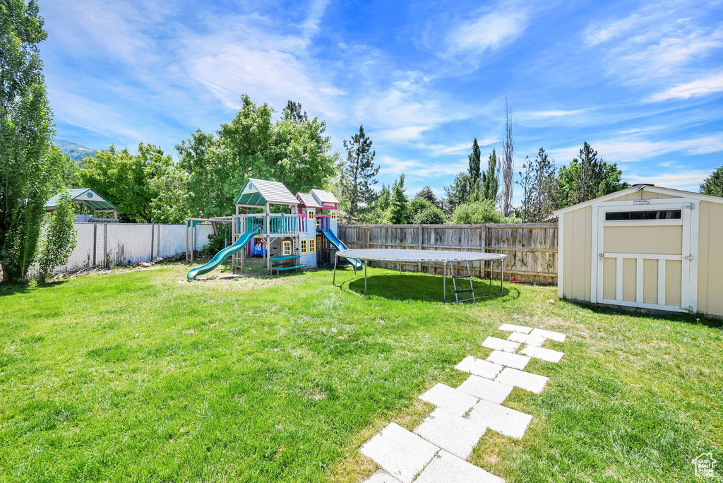 View of yard featuring a playground and a trampoline