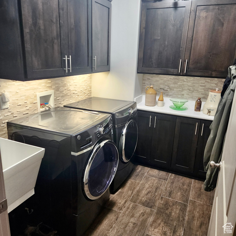 Washroom featuring cabinet space, separate washer and dryer, and wood finish floors