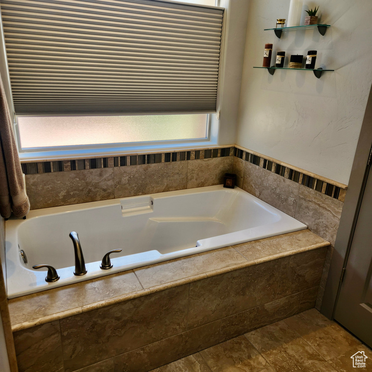 Bathroom featuring healthy amount of natural light and a garden tub