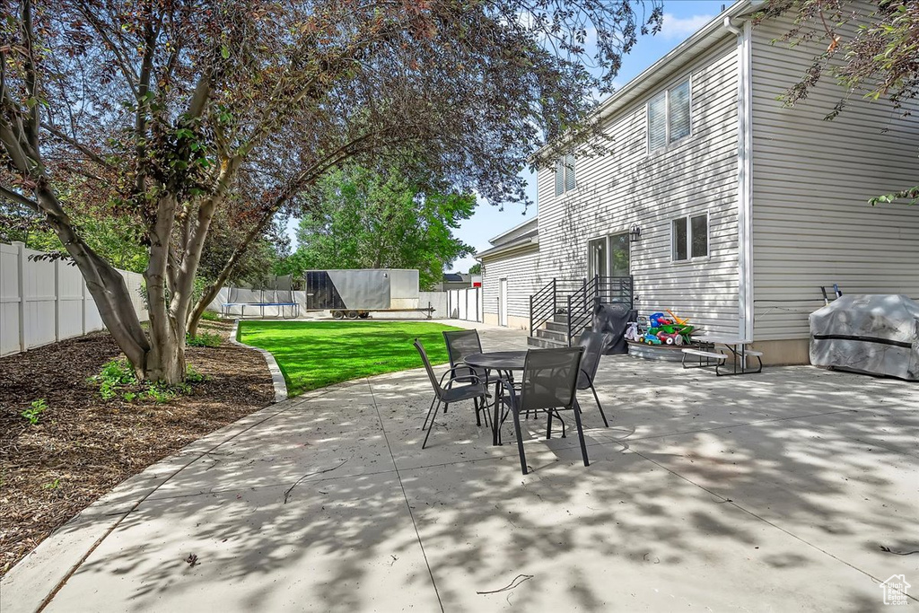 View of patio / terrace with a trampoline, outdoor dining area, and area for grilling