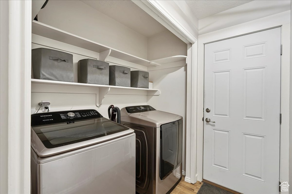 Laundry room featuring independent washer and dryer and light wood finished floors