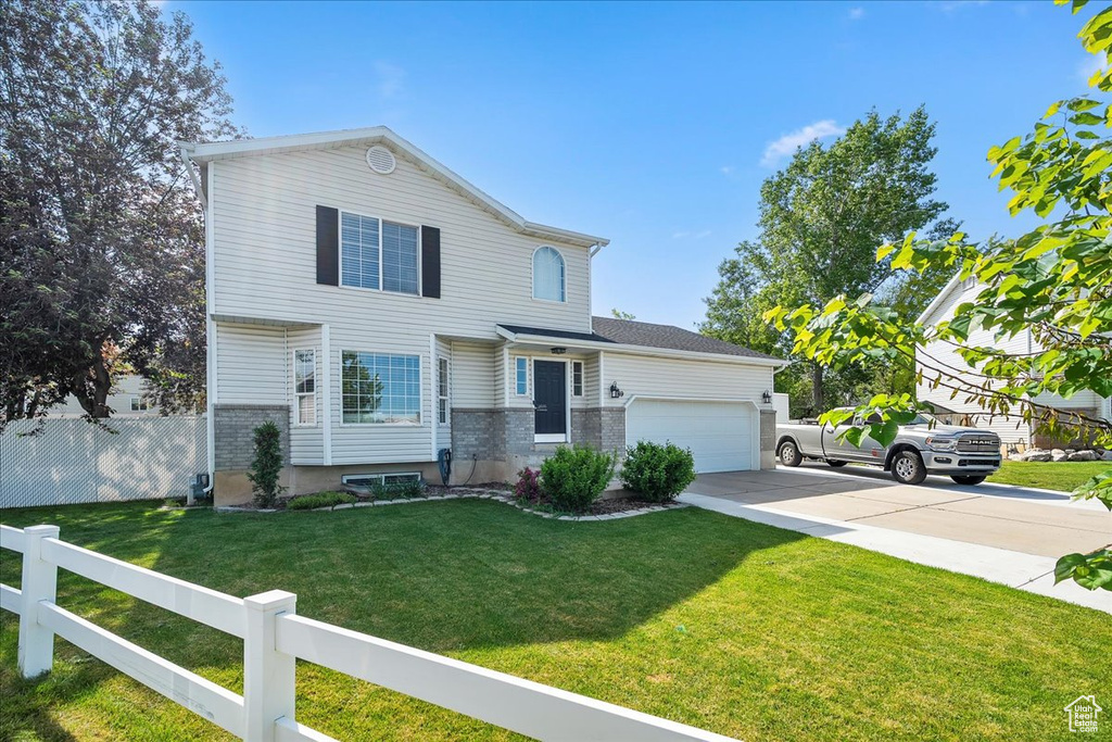 View of front of property with concrete driveway, an attached garage, and brick siding
