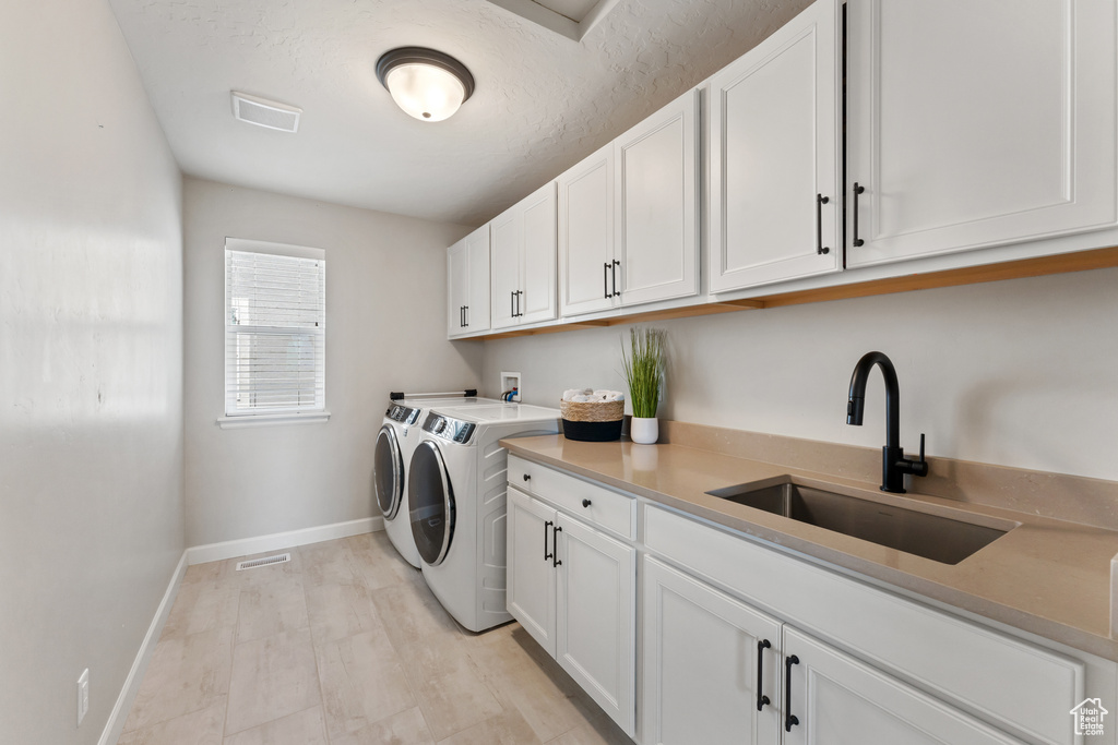 Washroom with washer and clothes dryer, baseboards, and cabinet space