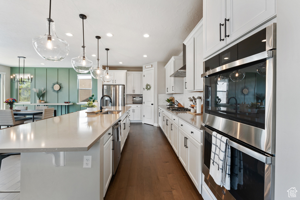 Kitchen with appliances with stainless steel finishes, recessed lighting, light countertops, and white cabinetry