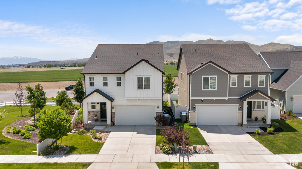 View of front of property with a garage, board and batten siding, and a mountain view